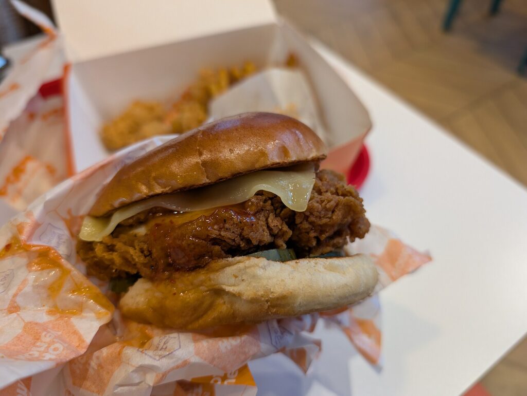 Kanapka Popeyes z panierowanym kurczakiem, serem i sosem