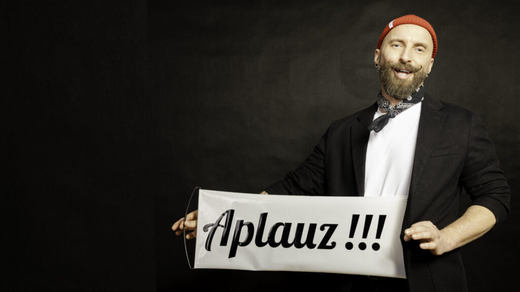 Pan Ząbek, iluzjonista i komik, z tabliczką „Aplauz!!!”